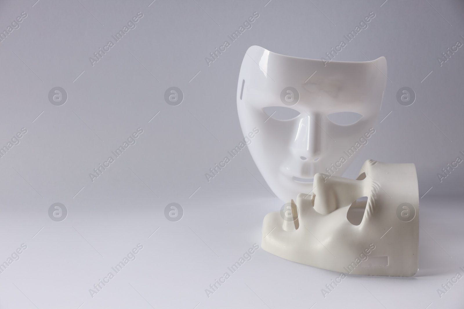 Photo of Plastic face masks on white background, space for text. Theatrical performance