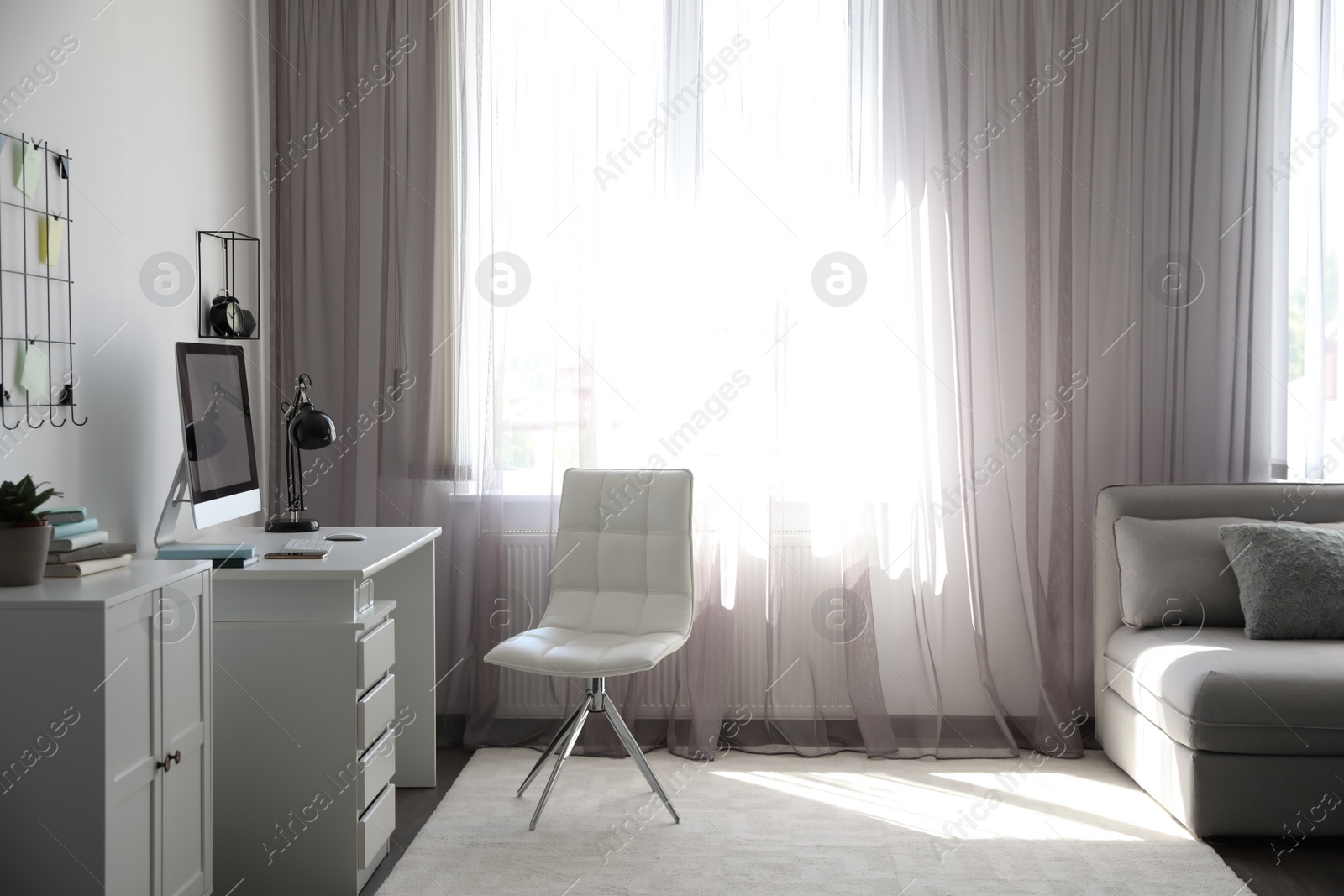 Photo of Comfortable white chair near desk in stylish office interior