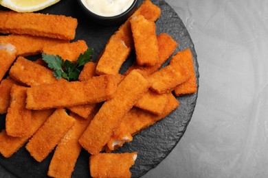 Tasty fresh fish fingers served on black table, top view