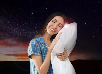 Image of Beautiful woman holding pillow, night starry sky on background. Bedtime