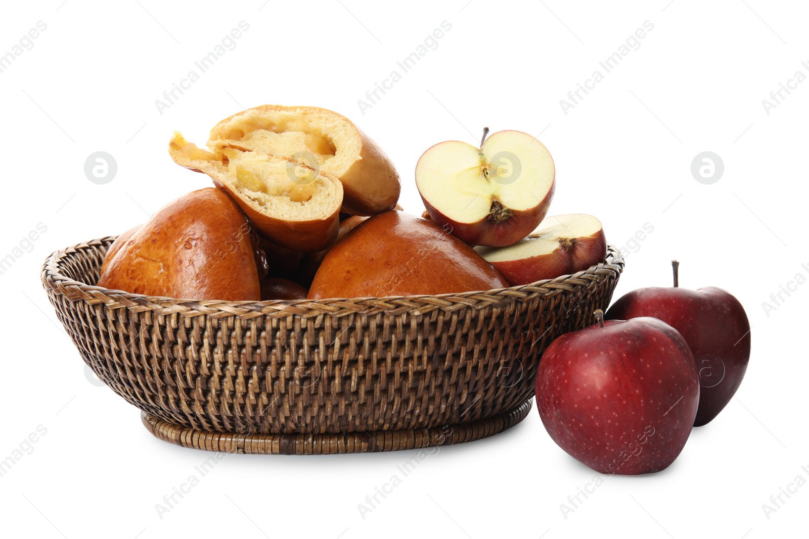 Photo of Delicious baked apple pirozhki in wicker basket and fruits on white background