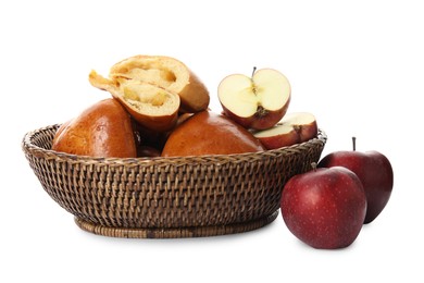 Delicious baked apple pirozhki in wicker basket and fruits on white background