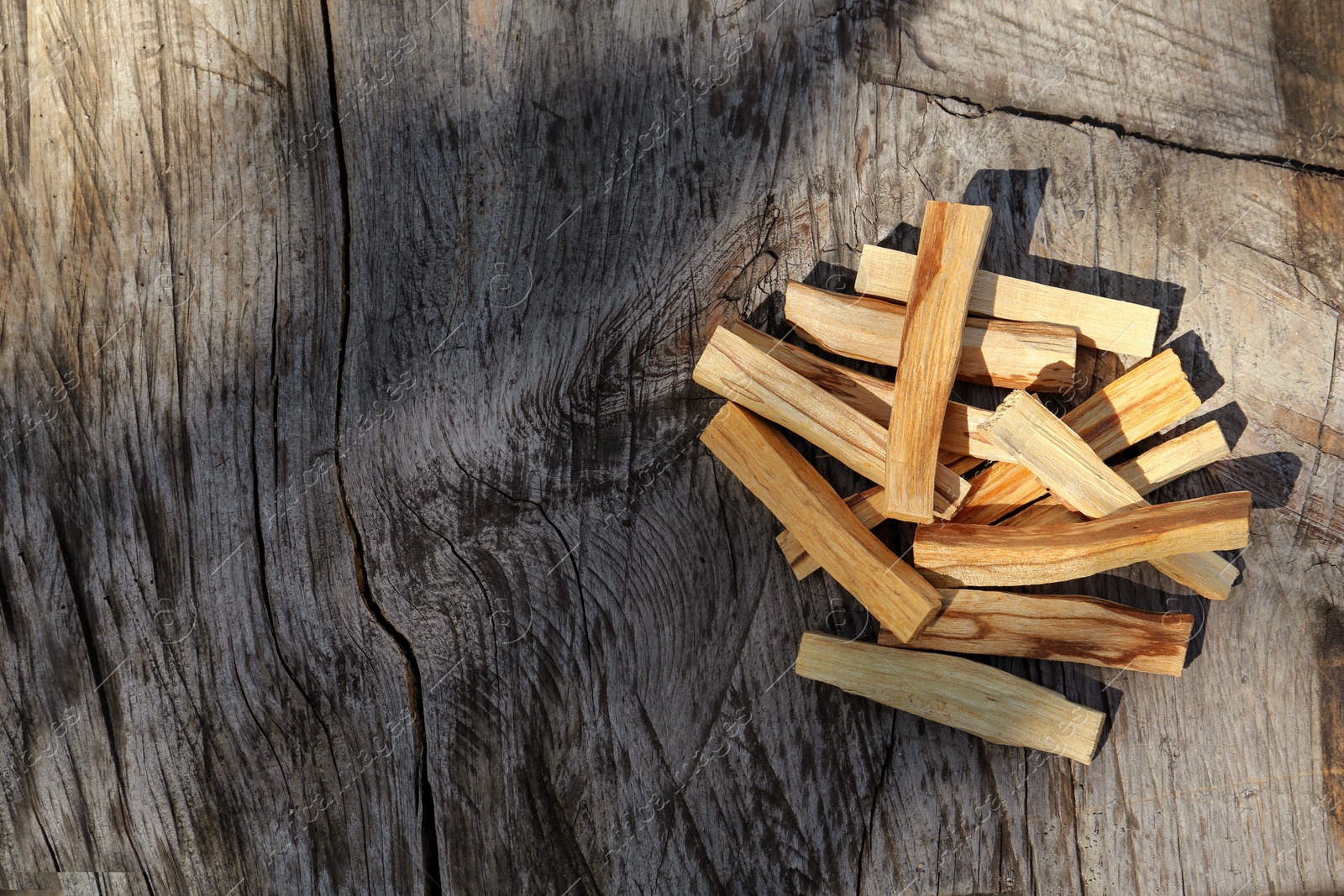 Photo of Palo santo sticks on wooden table, top view. Space for text