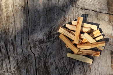 Palo santo sticks on wooden table, top view. Space for text