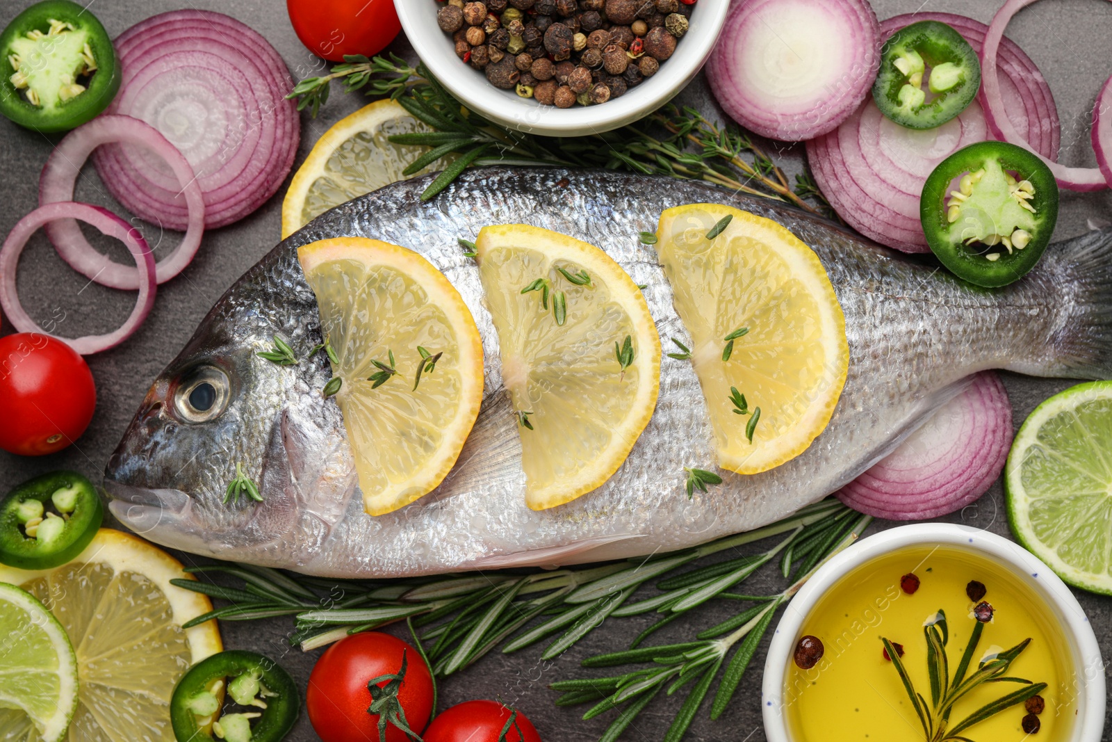 Photo of Fresh dorado fish and spices on black table, flat lay