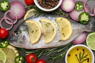 Fresh dorado fish and spices on black table, flat lay