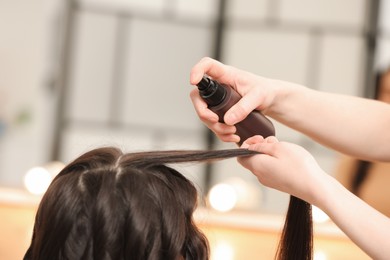 Photo of Hair styling. Professional hairdresser working with client indoors, closeup