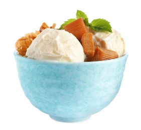 Bowl of delicious ice cream with caramel candies, popcorn and mint on white background