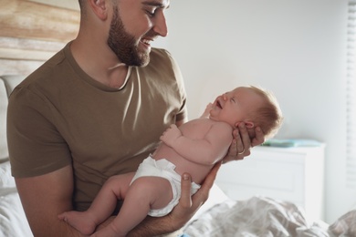 Photo of Father with his newborn son at home