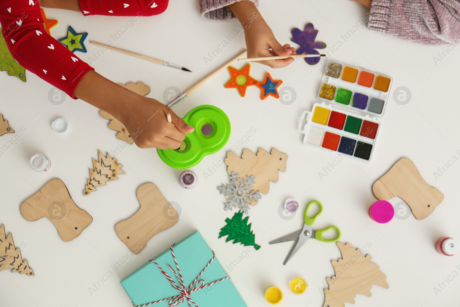 Photo of Children making Christmas crafts at table, top view