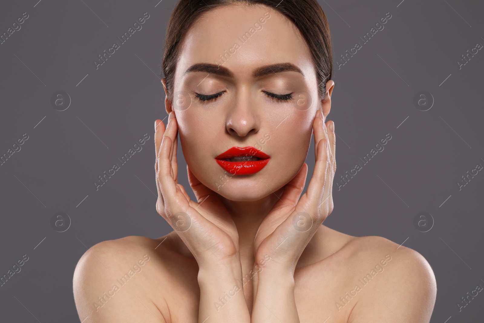 Photo of Young woman with red lips makeup on grey background