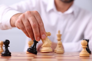 Photo of Man moving chess pieces on checkerboard, closeup