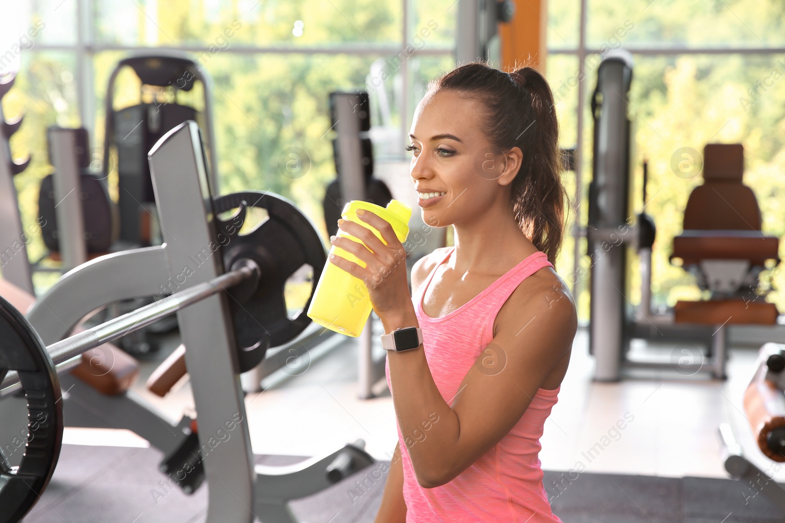 Photo of Portrait of athletic woman with protein shake in gym