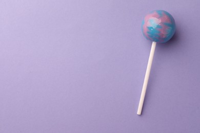 Photo of Tasty lollipop on violet background, top view. Space for text