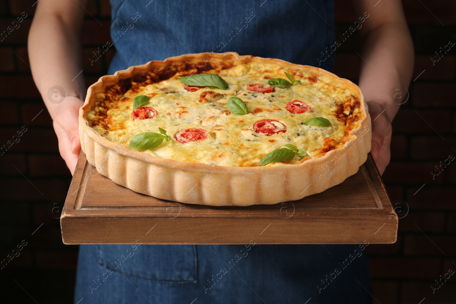 Photo of Woman with delicious homemade cheese quiche indoors, closeup