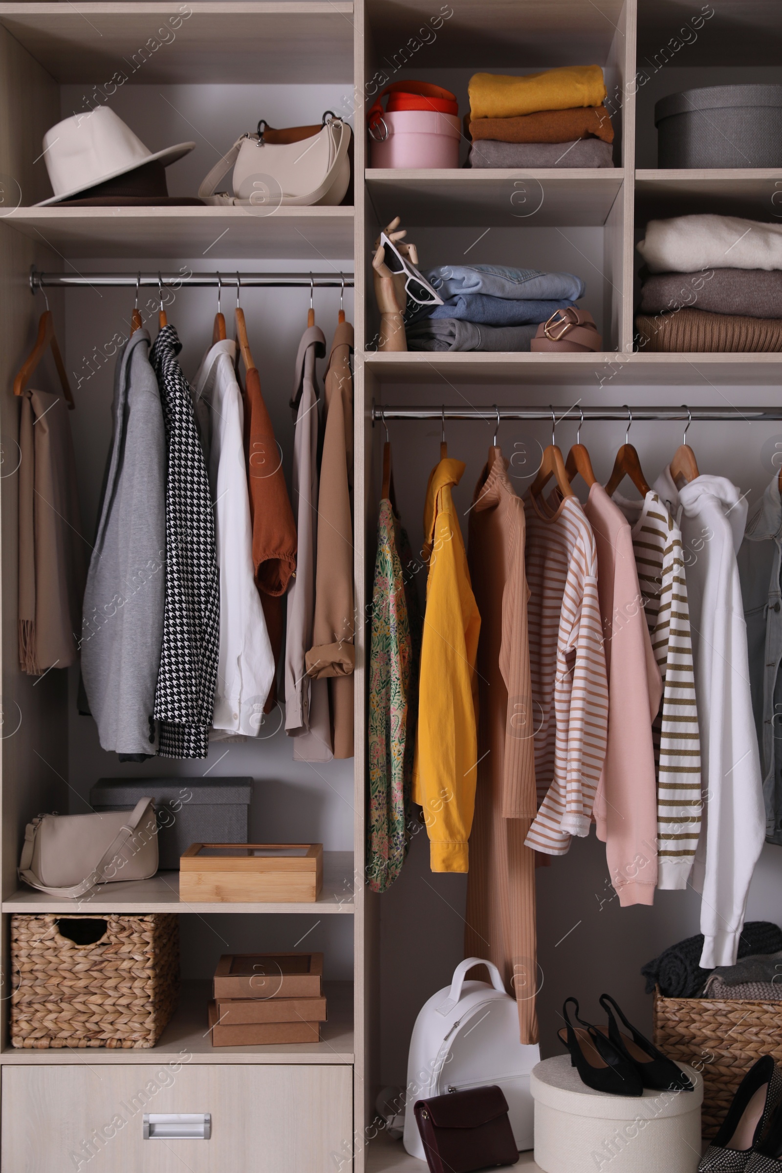 Photo of Wardrobe closet with different stylish clothes, accessories and home stuff