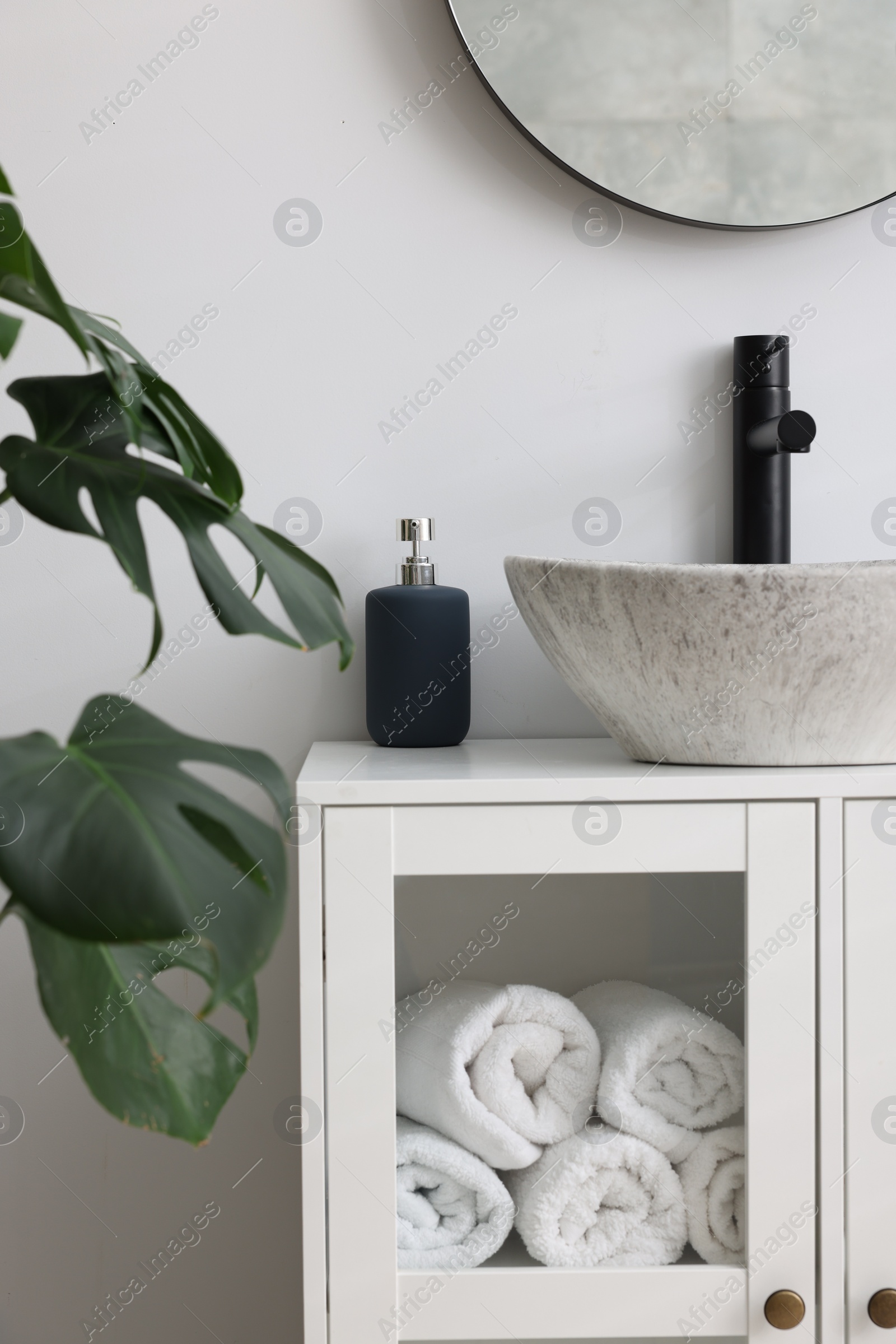 Photo of Different bath accessories and personal care products near sink on bathroom vanity
