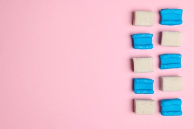 Photo of Different tasty colorful bubble gums on pink background, flat lay. Space for text