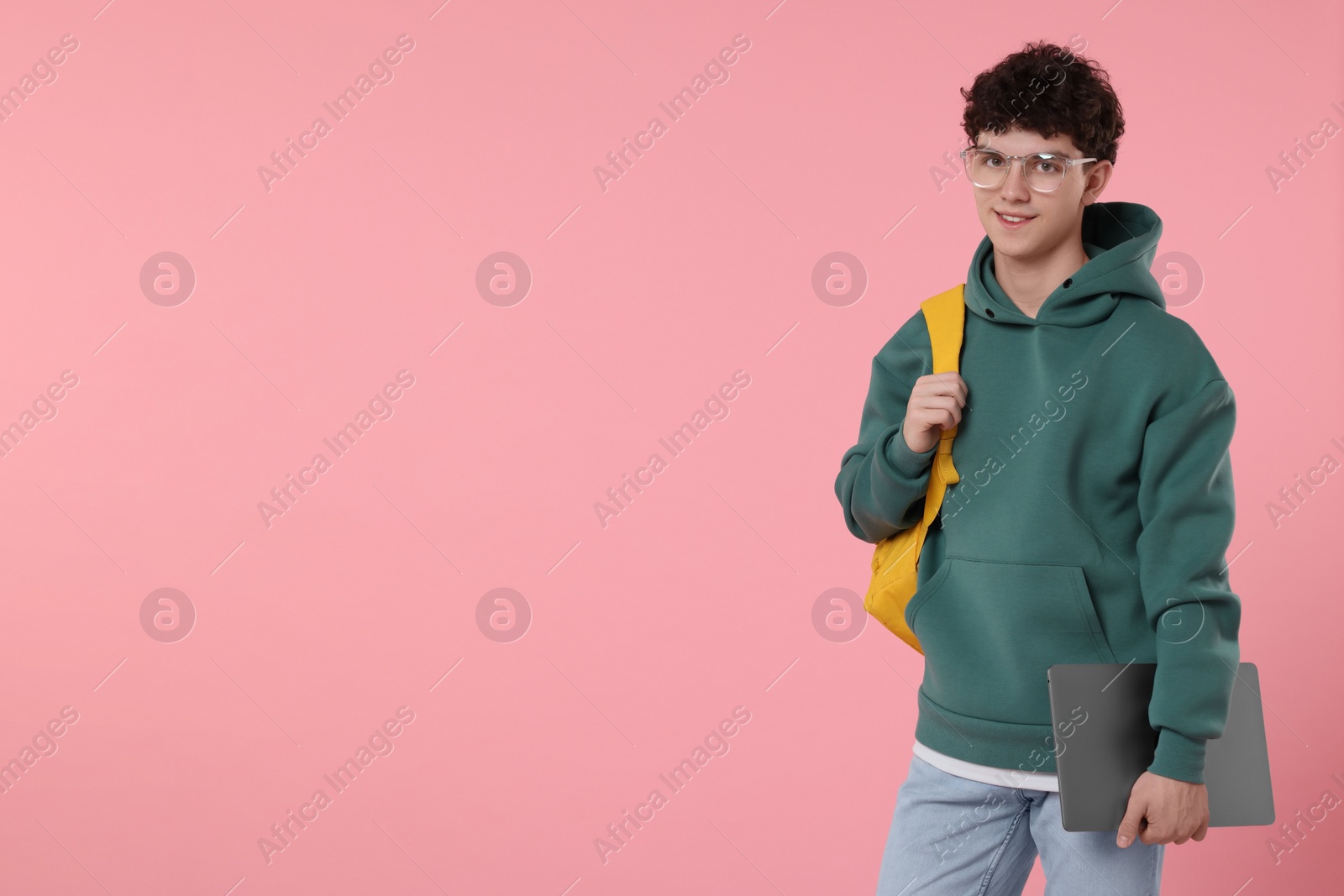 Photo of Portrait of student with backpack and laptop on pink background. Space for text