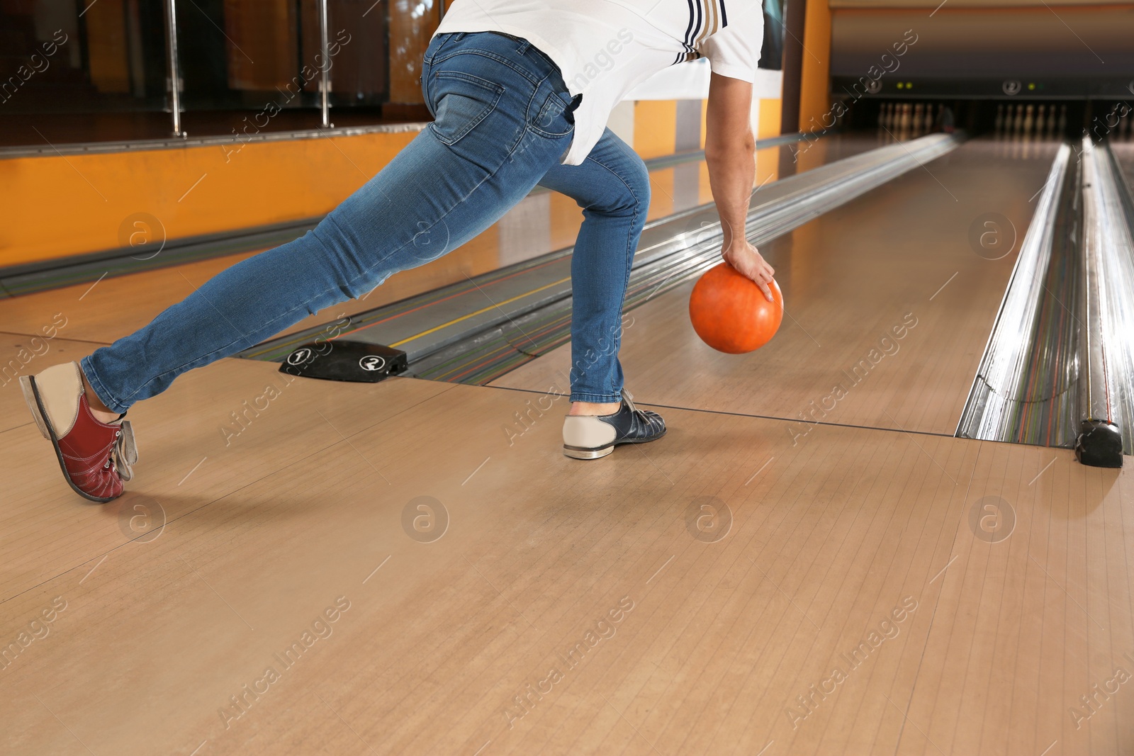 Photo of Young man throwing ball in bowling club, closeup
