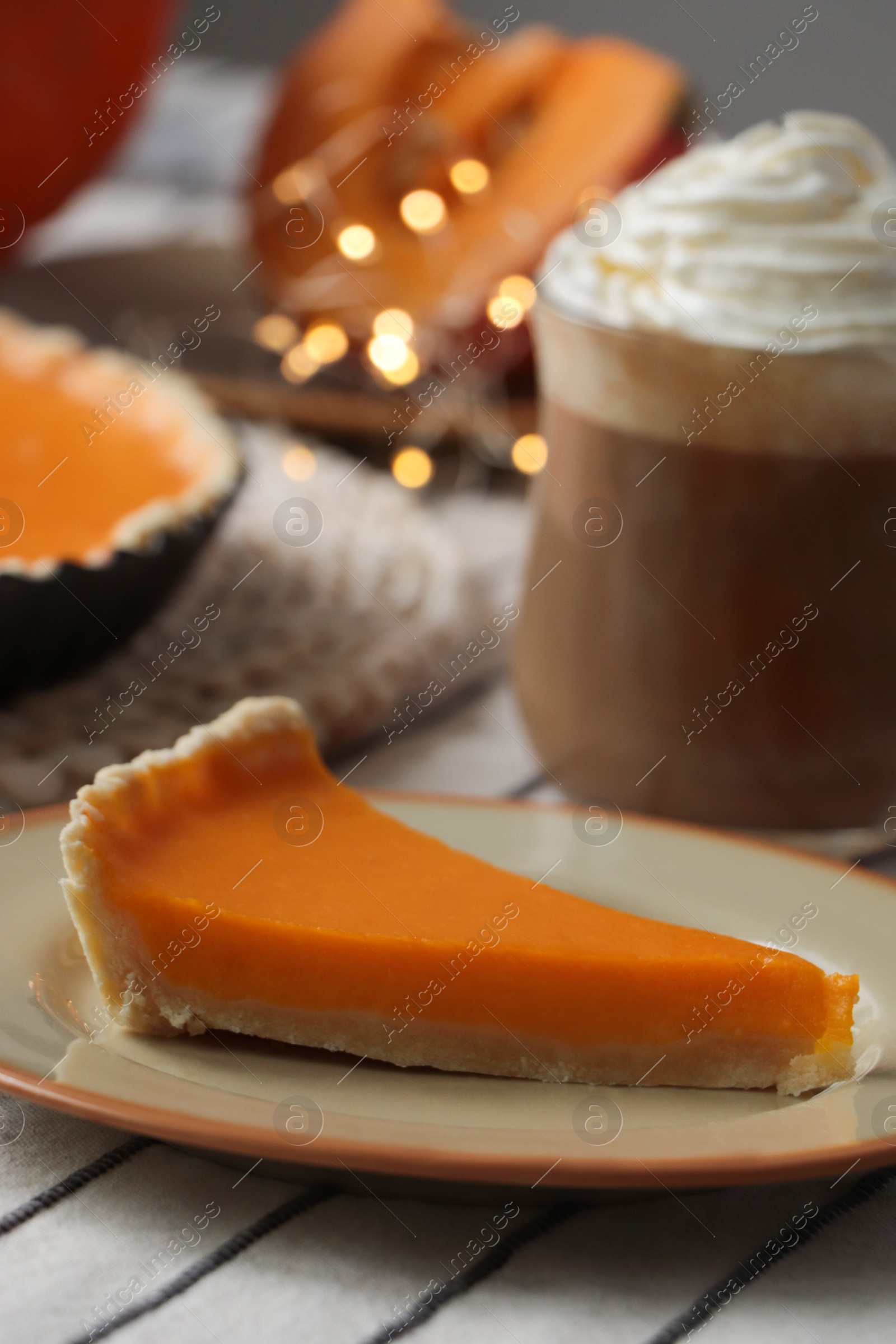 Photo of Fresh homemade pumpkin pie and cup of cocoa with whipped cream on table