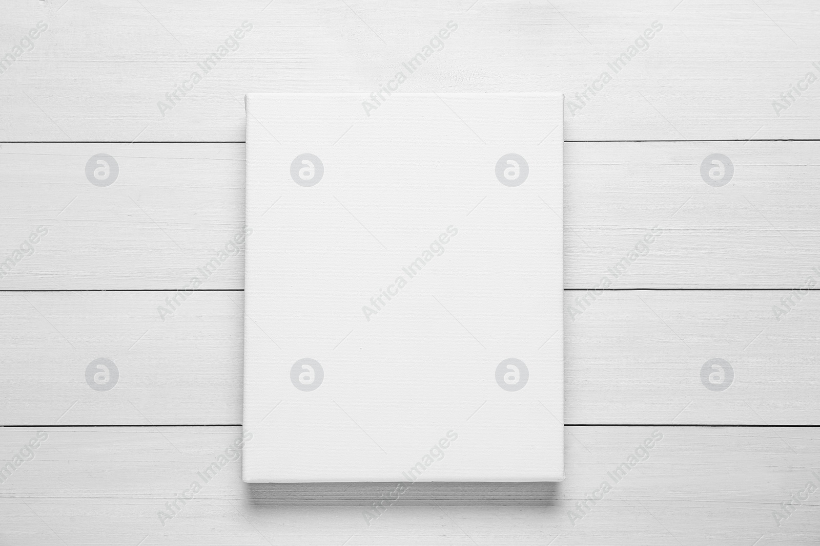 Photo of Blank canvas on white wooden background, top view. Space for design