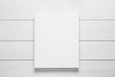 Photo of Blank canvas on white wooden background, top view. Space for design