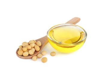 Photo of Glass bowl of oil, soybeans and wooden spoon on white background