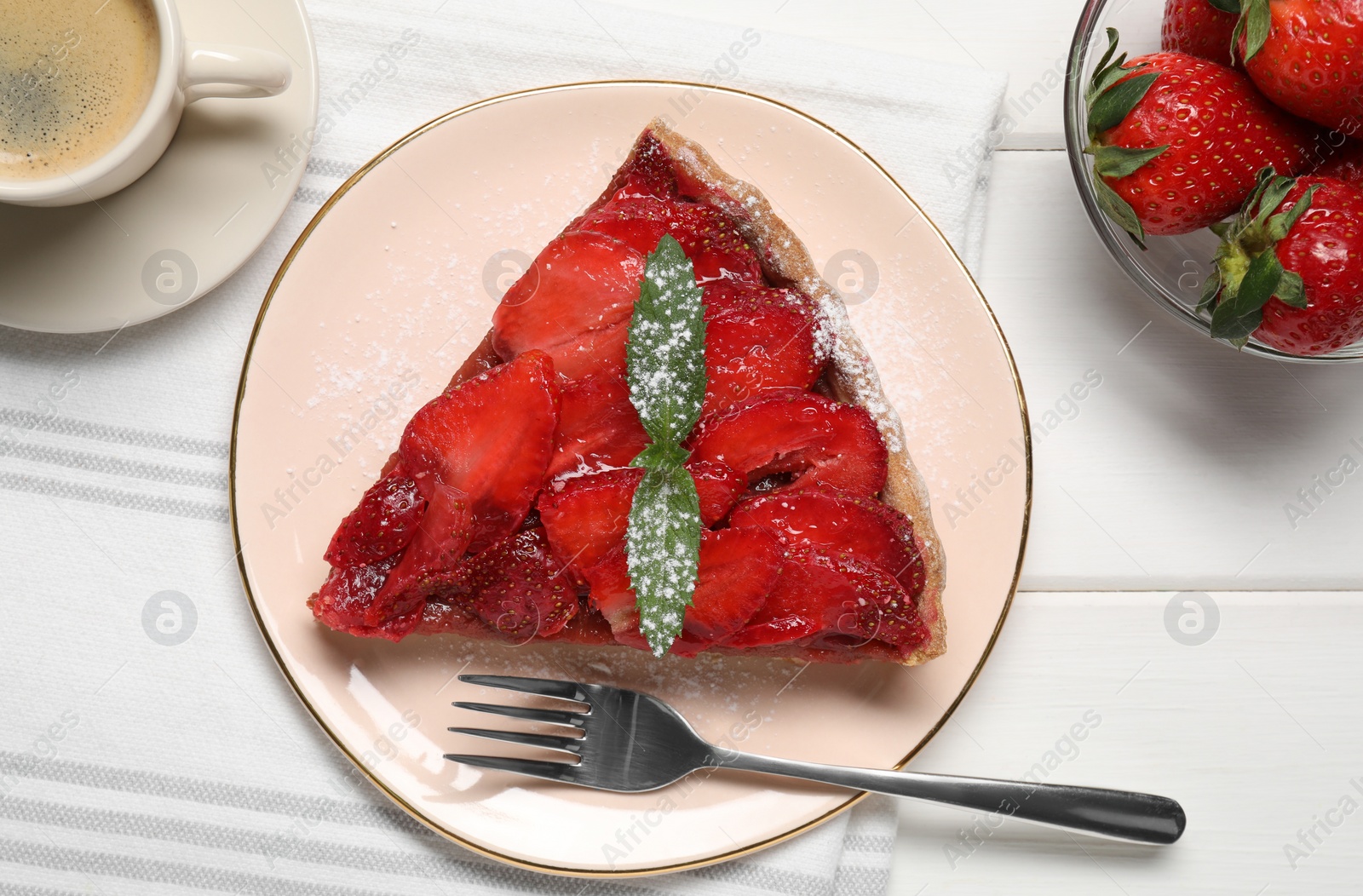 Photo of Piece of delicious strawberry tart with mint and coffee on white wooden table, flat lay