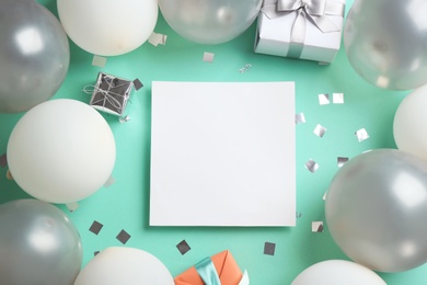 Flat lay composition with air balloons and blank card for text on color background