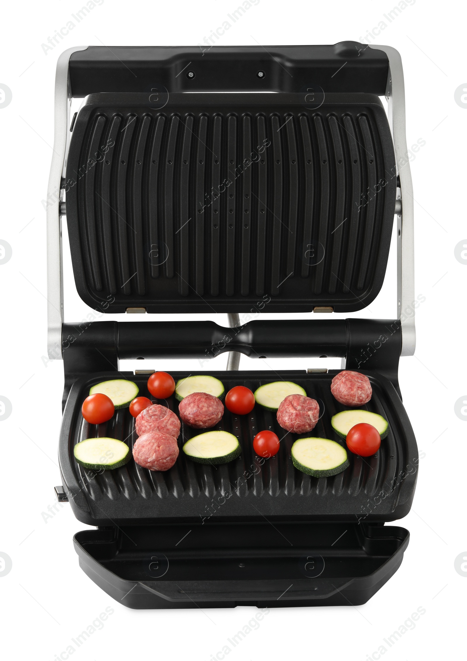 Photo of Electric grill with meat balls, zucchini and tomatoes isolated on white