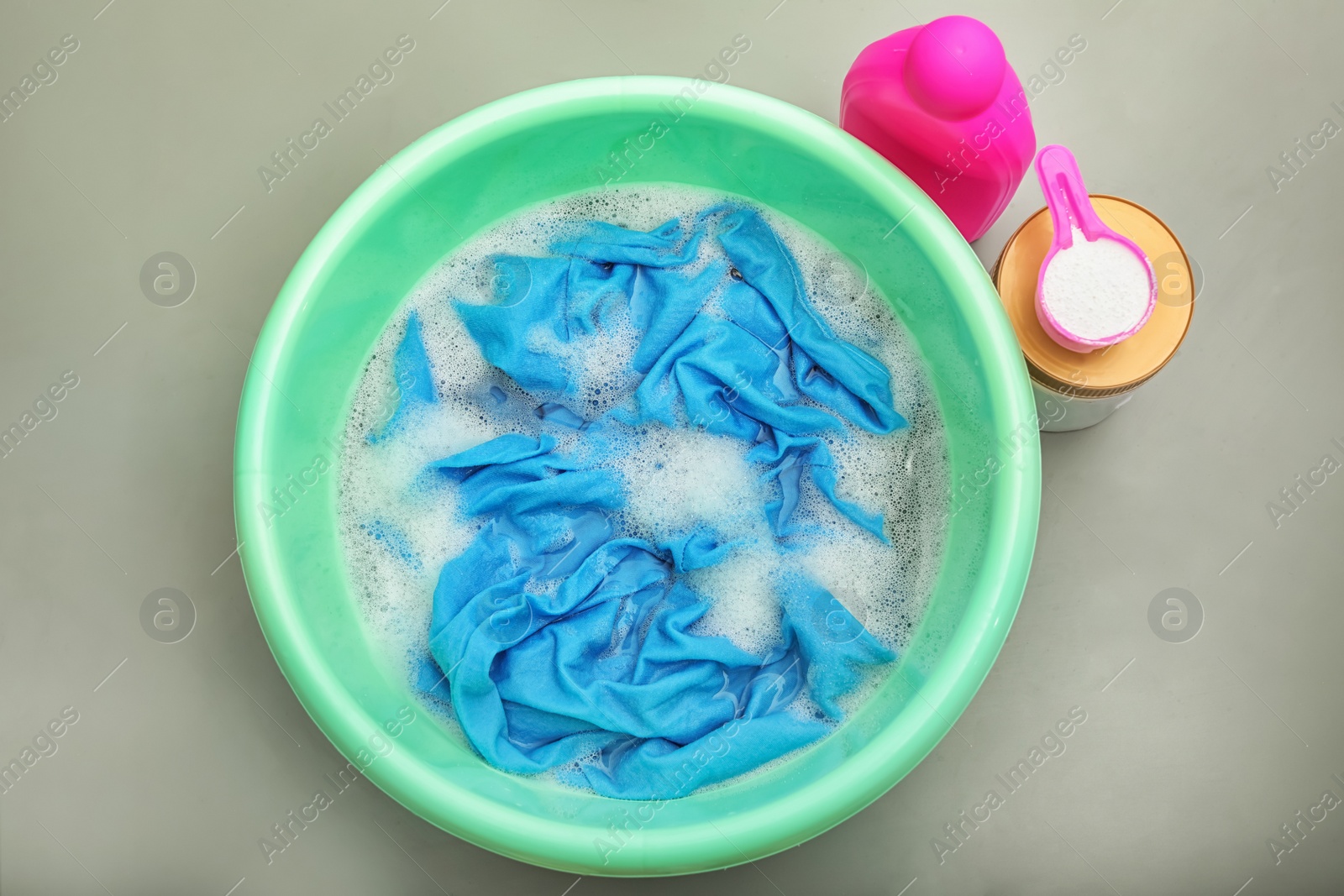 Photo of Color clothes with foam in basin, top view