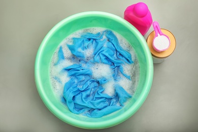 Photo of Color clothes with foam in basin, top view