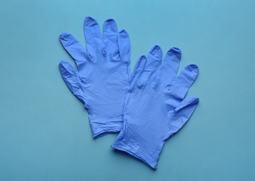Photo of Pair of medical gloves on blue background, flat lay
