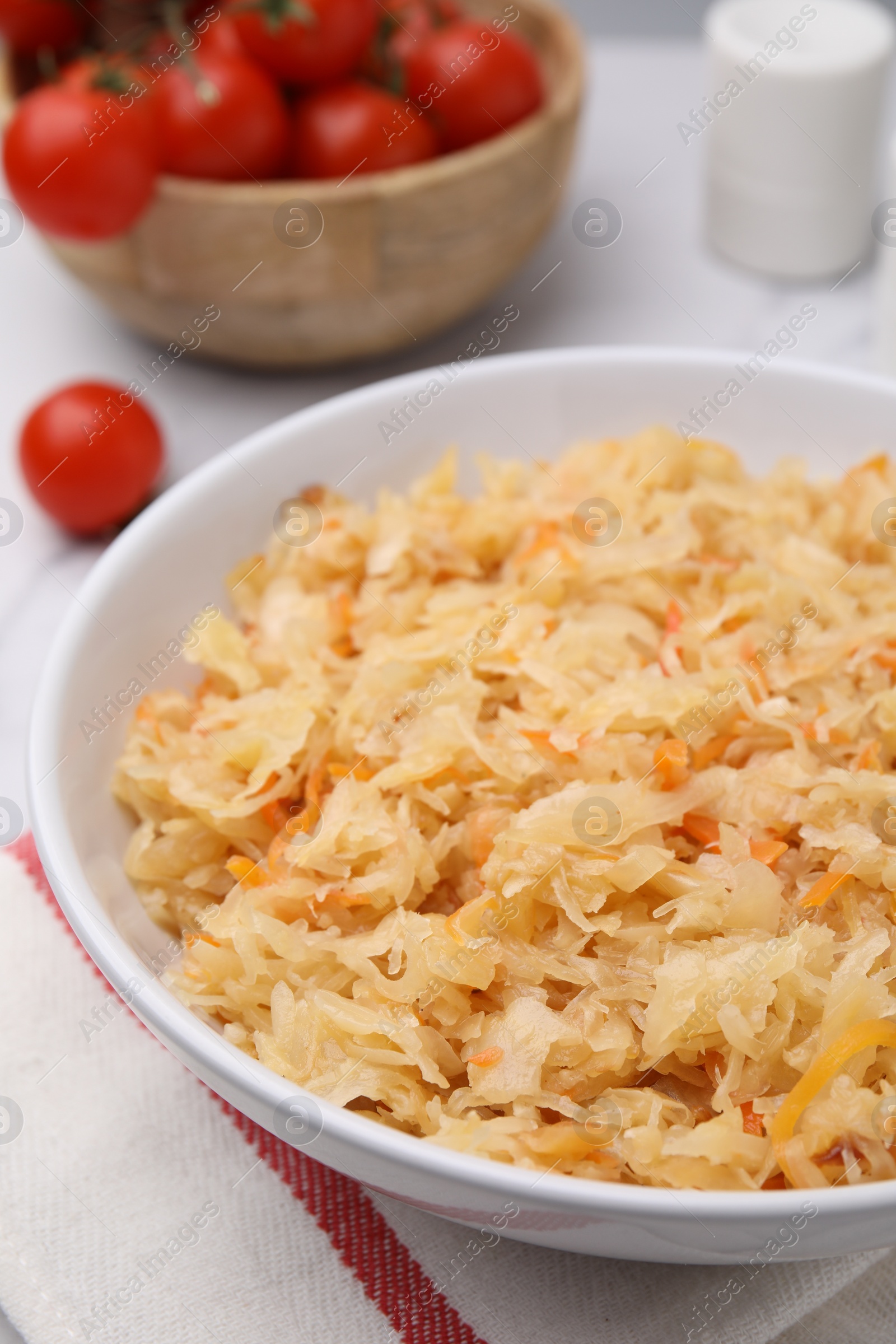 Photo of Bowl with tasty sauerkraut on table, closeup