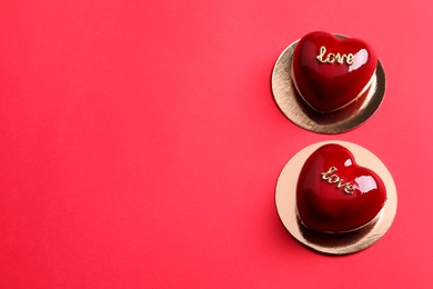 St. Valentine's Day. Delicious heart shaped cakes on red background, above view. Space for text