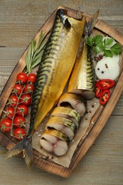 Delicious smoked mackerels and different products on wooden table, top view