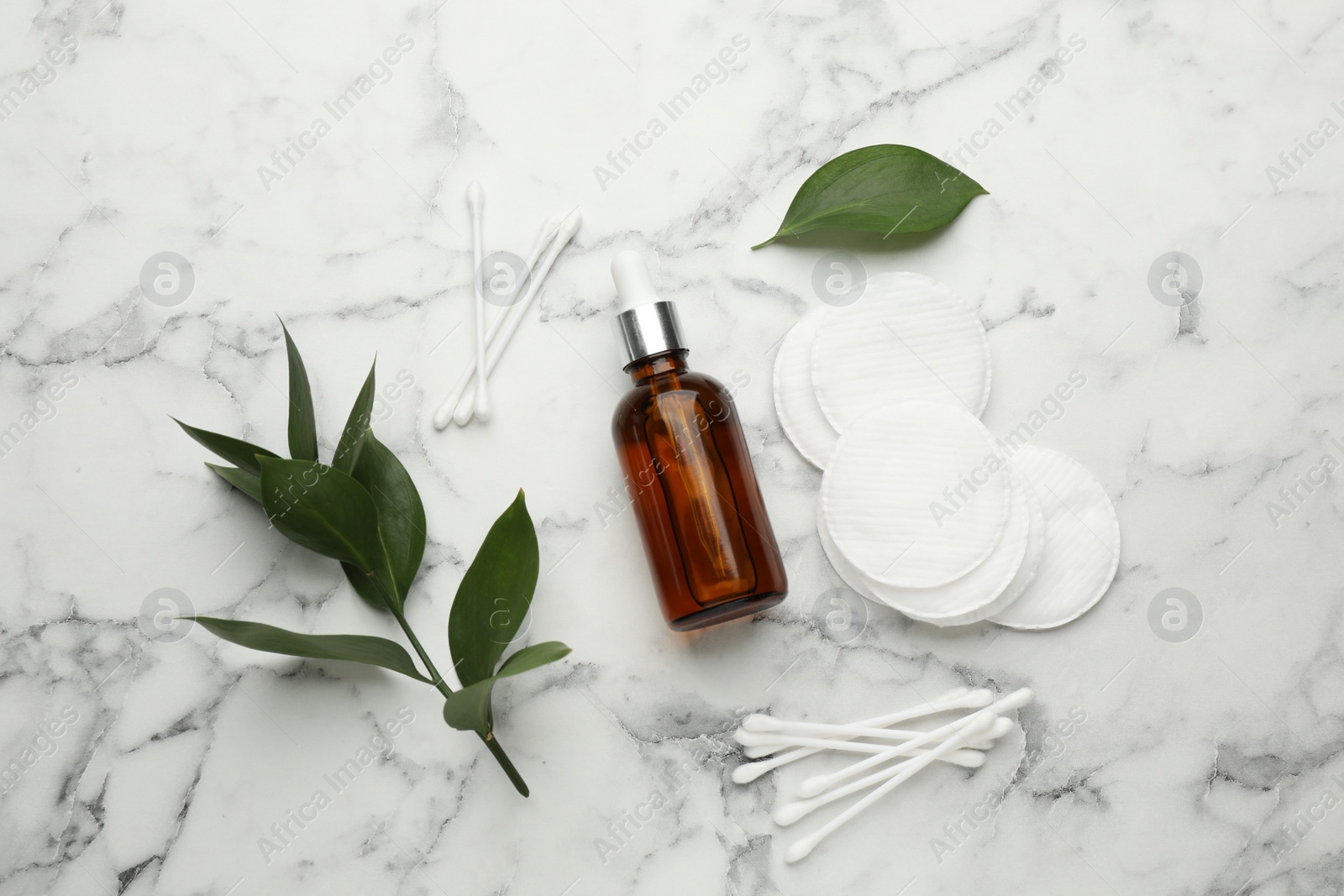 Photo of Cotton pads, swabs and makeup removal product on white marble table, flat lay