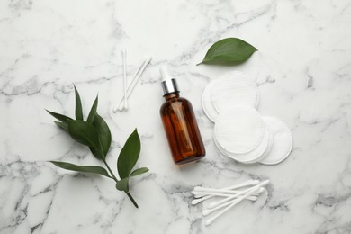 Photo of Cotton pads, swabs and makeup removal product on white marble table, flat lay