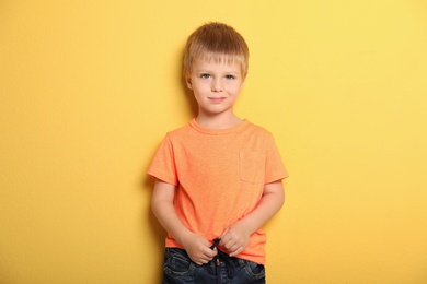 Portrait of cute little boy against color background