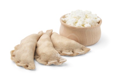 Photo of Raw dumplings (varenyky) and bowl with cottage cheese on white background