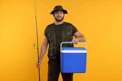 Photo of Fisherman with fishing rod and cool box on yellow background