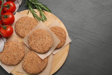Photo of Raw vegan cutlets with breadcrumbs on black table, flat lay. Space for text