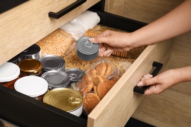 Photo of Woman taking food out from open drawer indoors, closeup