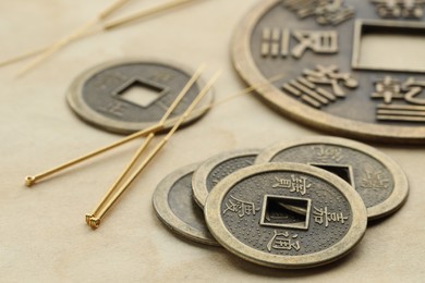 Acupuncture needles and Chinese coins on paper, closeup