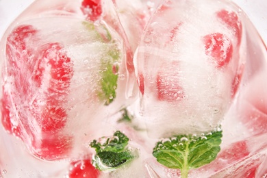 Photo of Ice cubes with pomegranate seeds and mint, closeup