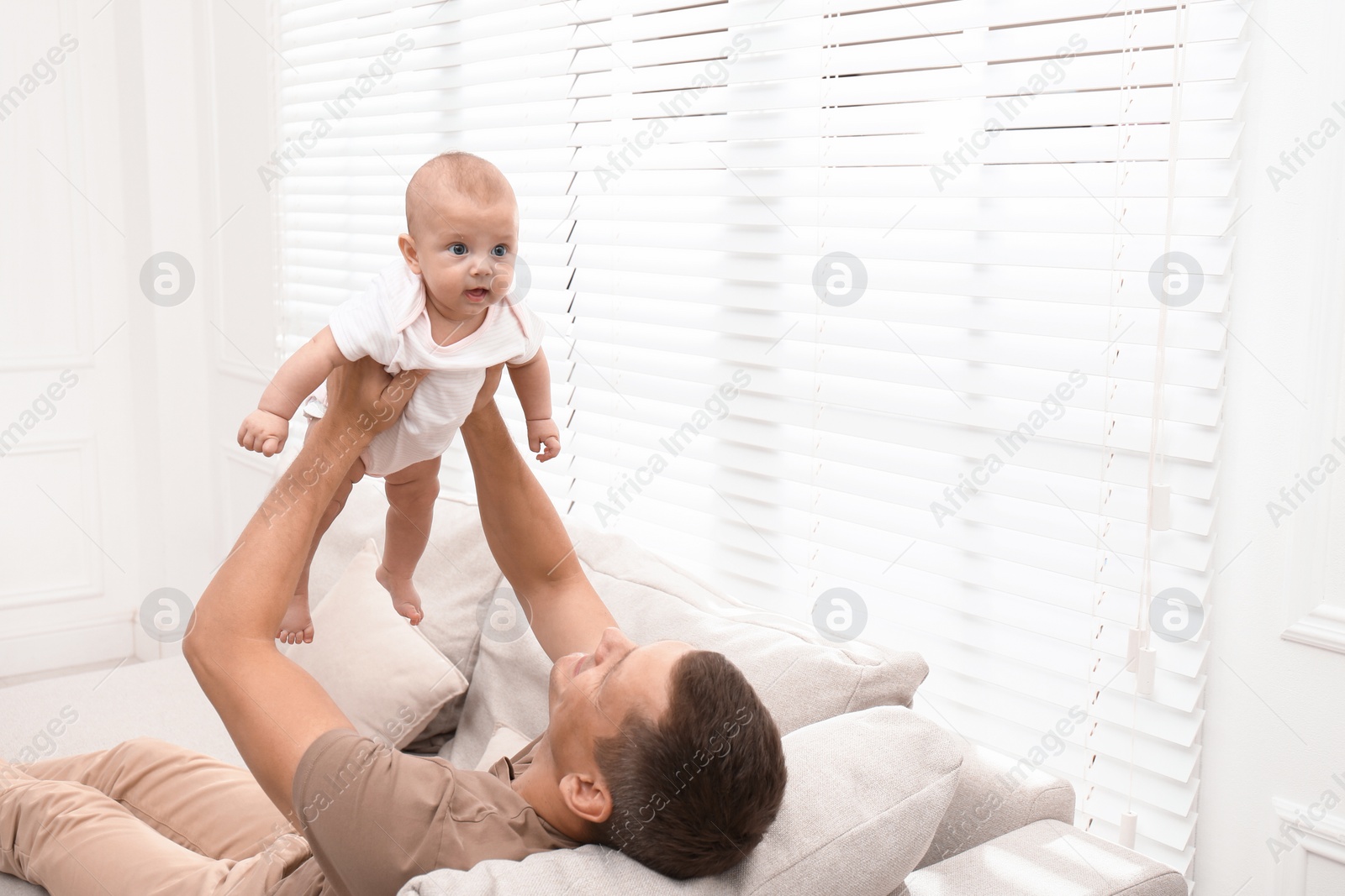 Photo of Happy father with his little baby at home. Space for text