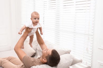 Photo of Happy father with his little baby at home. Space for text