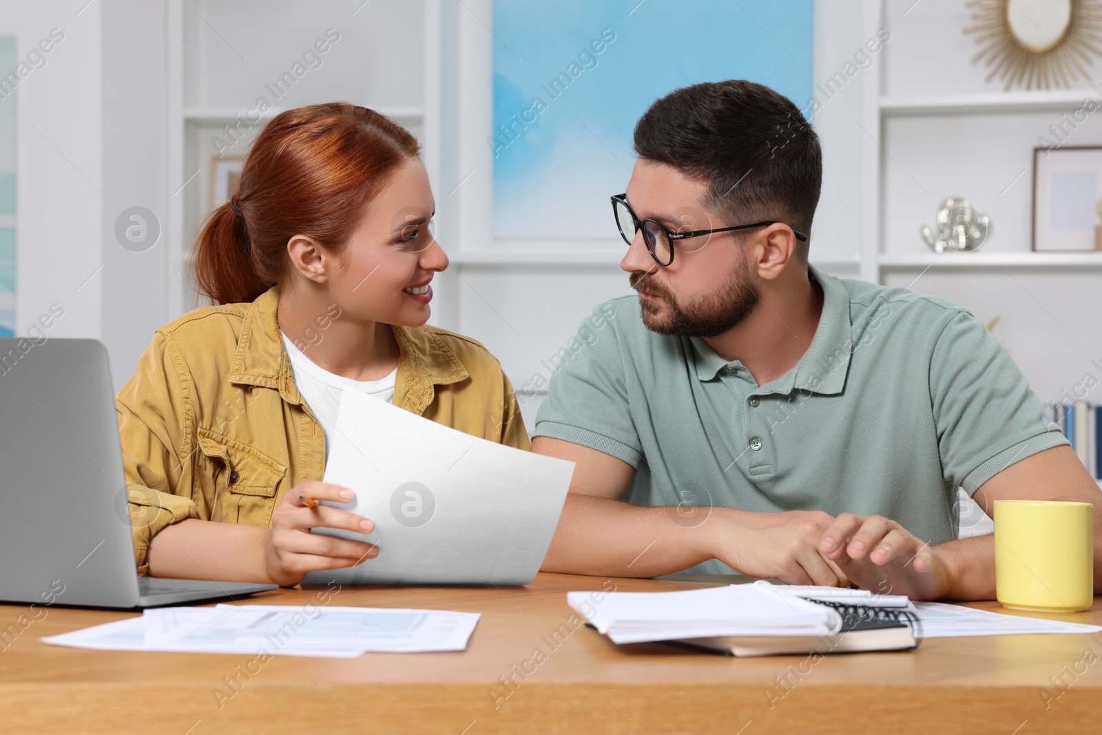 Photo of Couple doing taxes at table in room