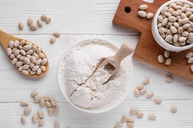 Photo of Kidney bean flour and seeds on white wooden table, flat lay